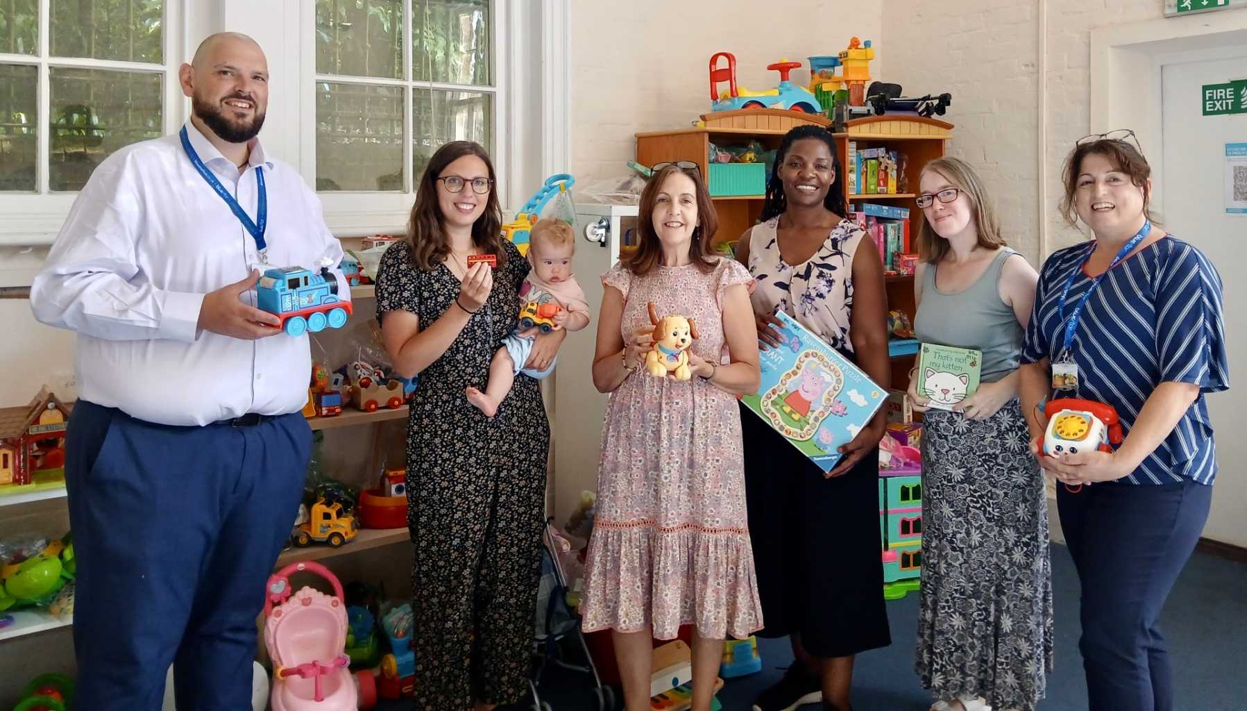 Group of people holding up toys 
