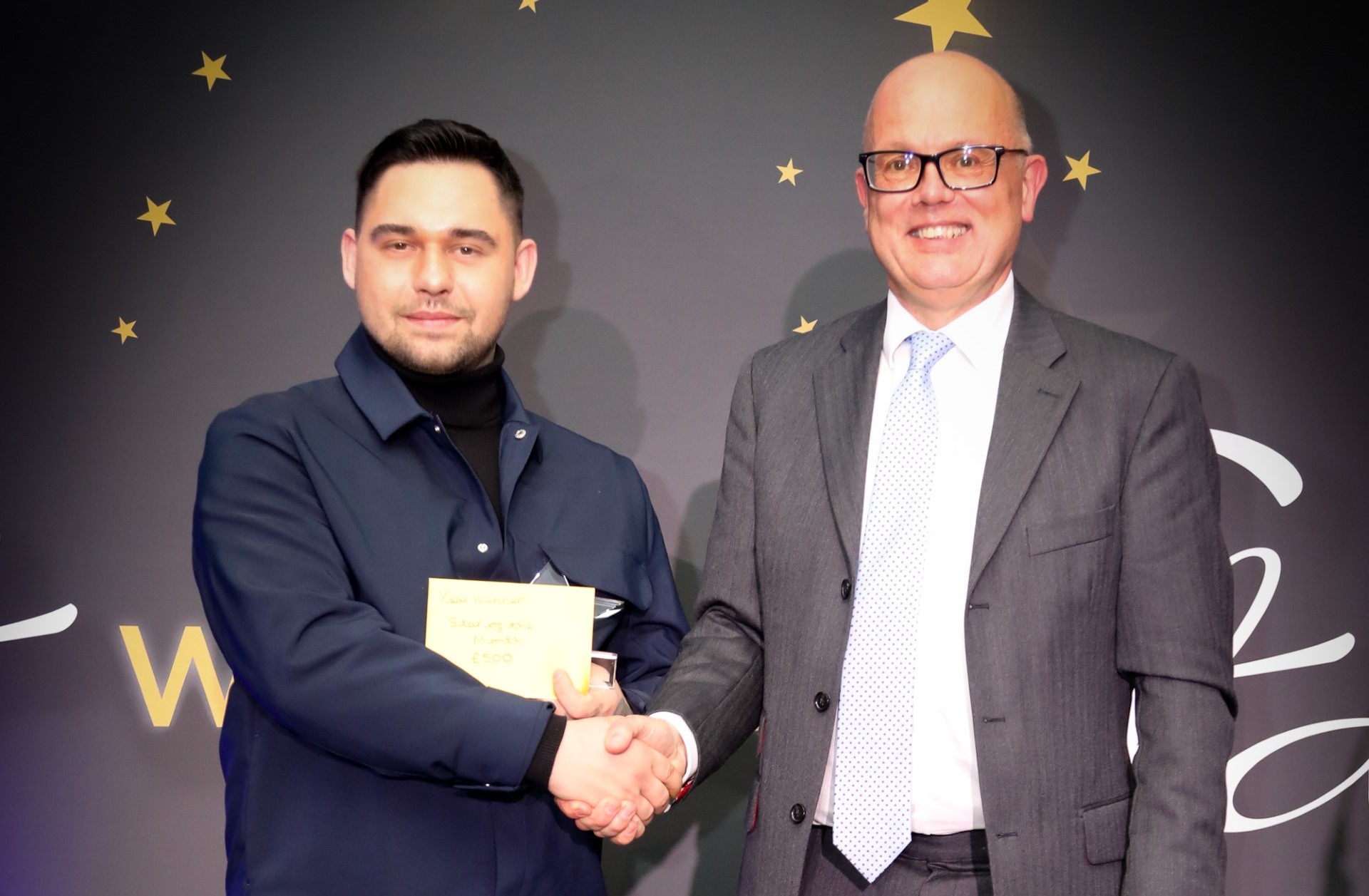 Bluestar's Daniel Kunicki shaking hands with managing director with an award