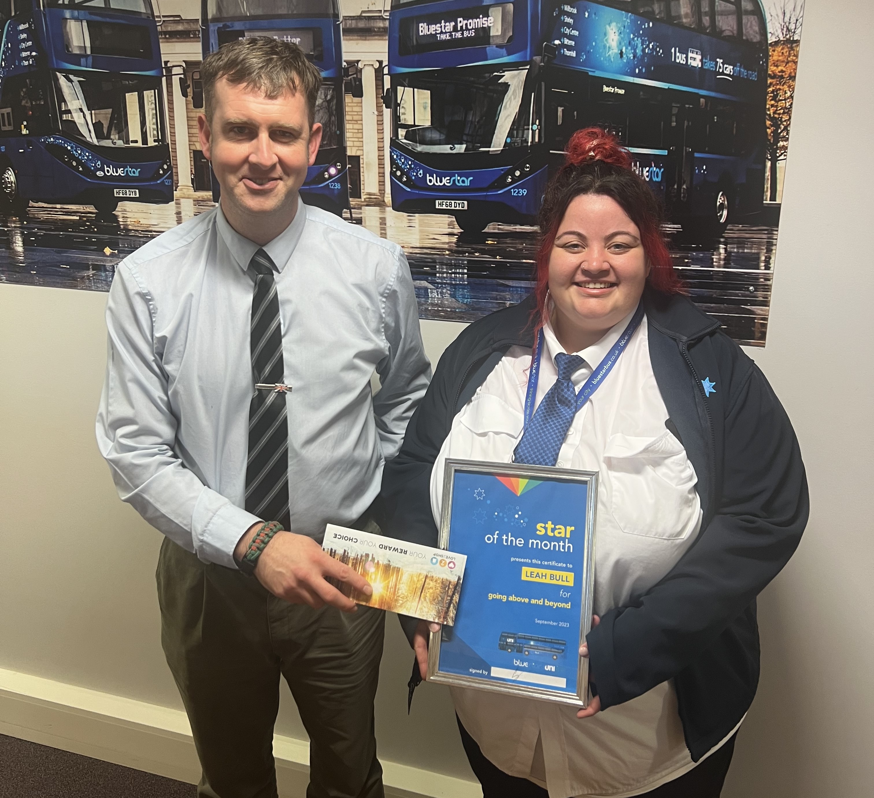 Bluestar manager presenting a certificate to a driver