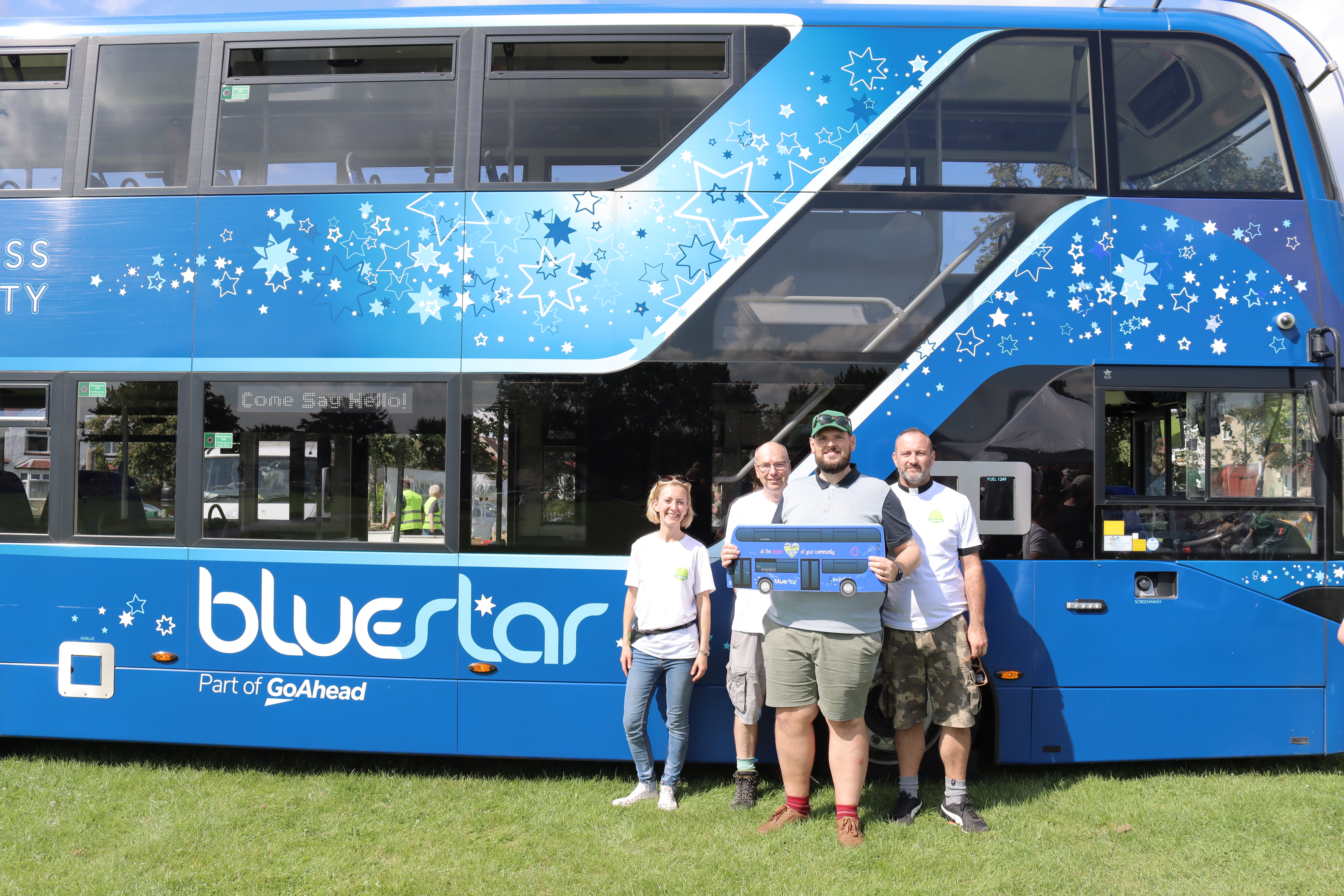 People stood next to Bluestar bus holding a bus cutout