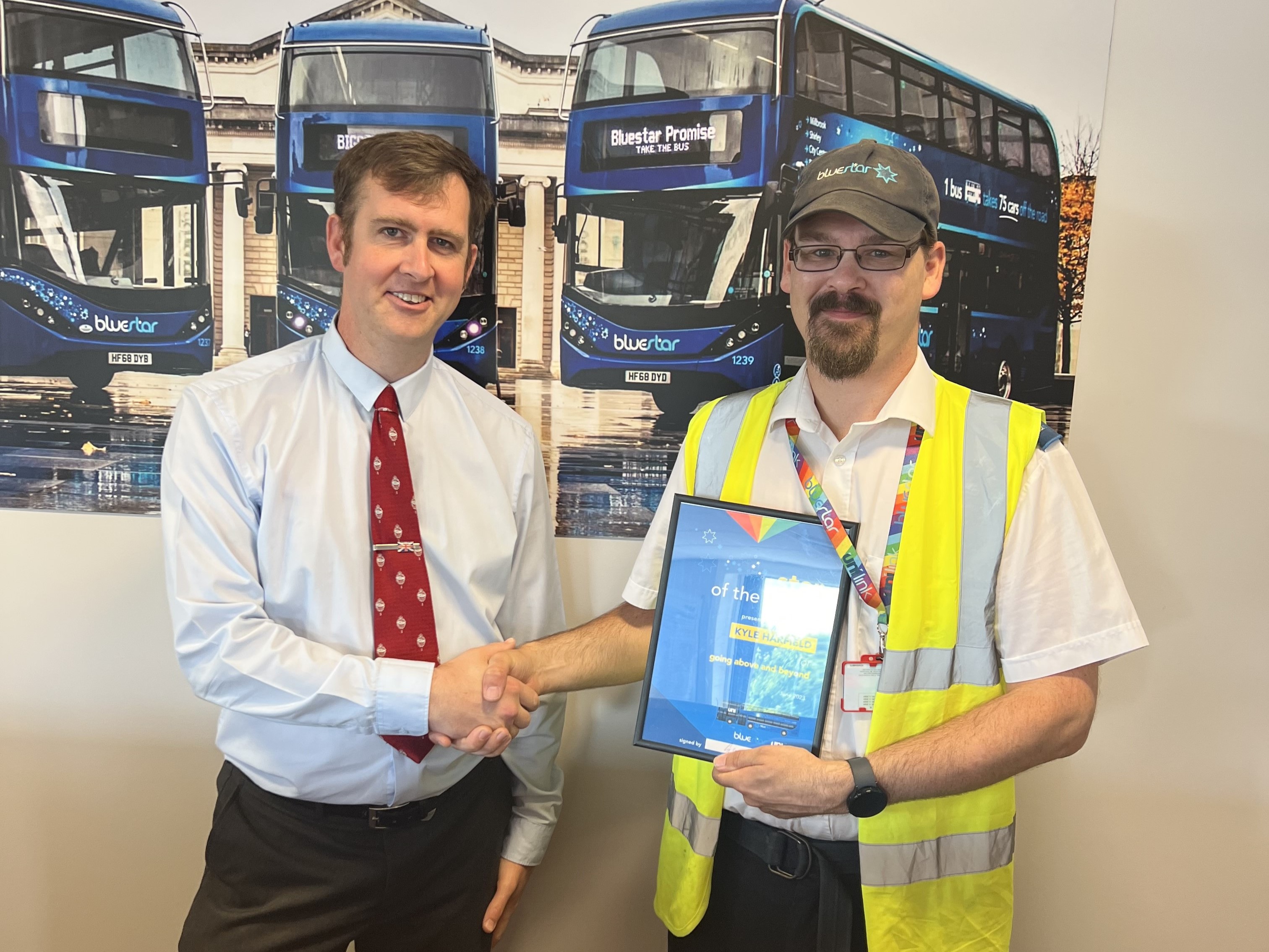 Bluestar manager presenting a certificate to a driver