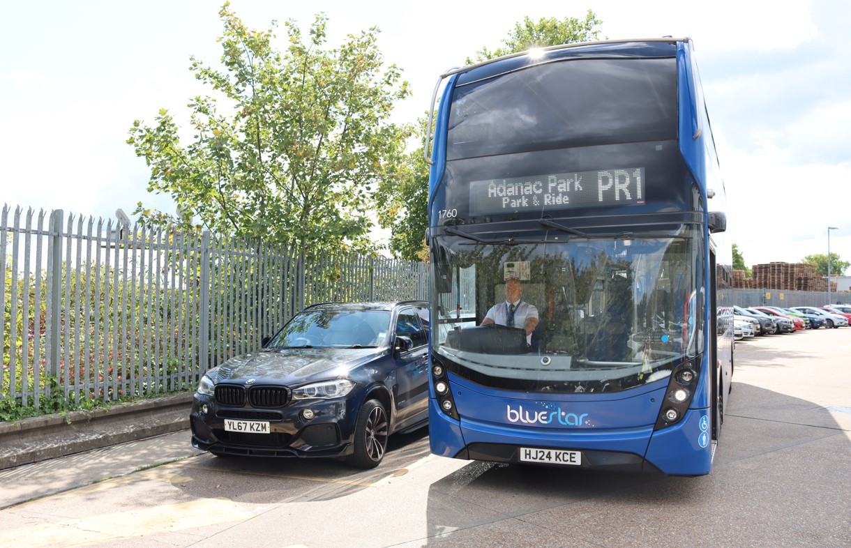 Bluestar double decker bus next to a car