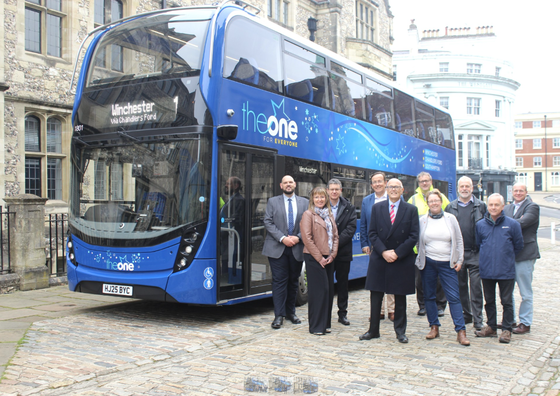 'The One' bus and group of peopleoutside the Great Hall Winchester