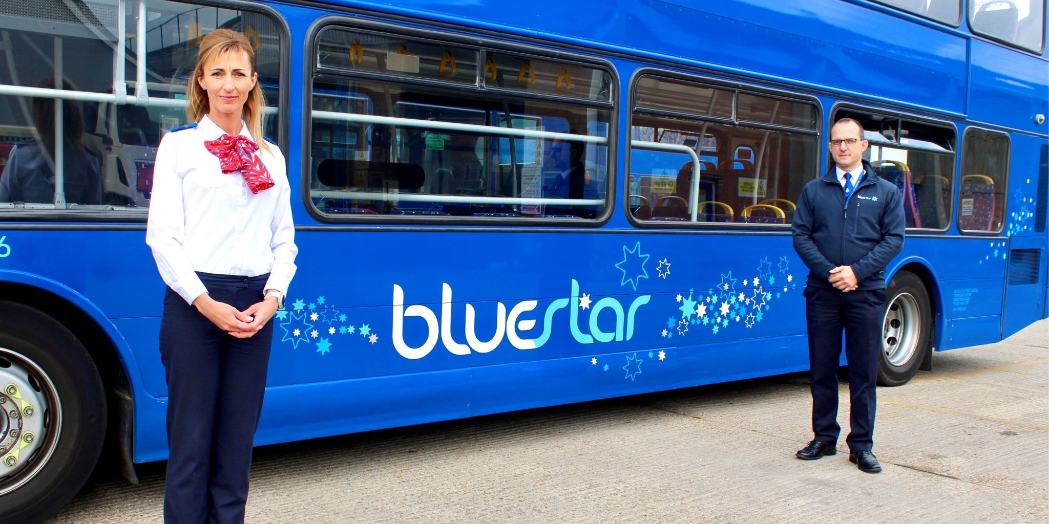 Two bus drivers in front of a bus